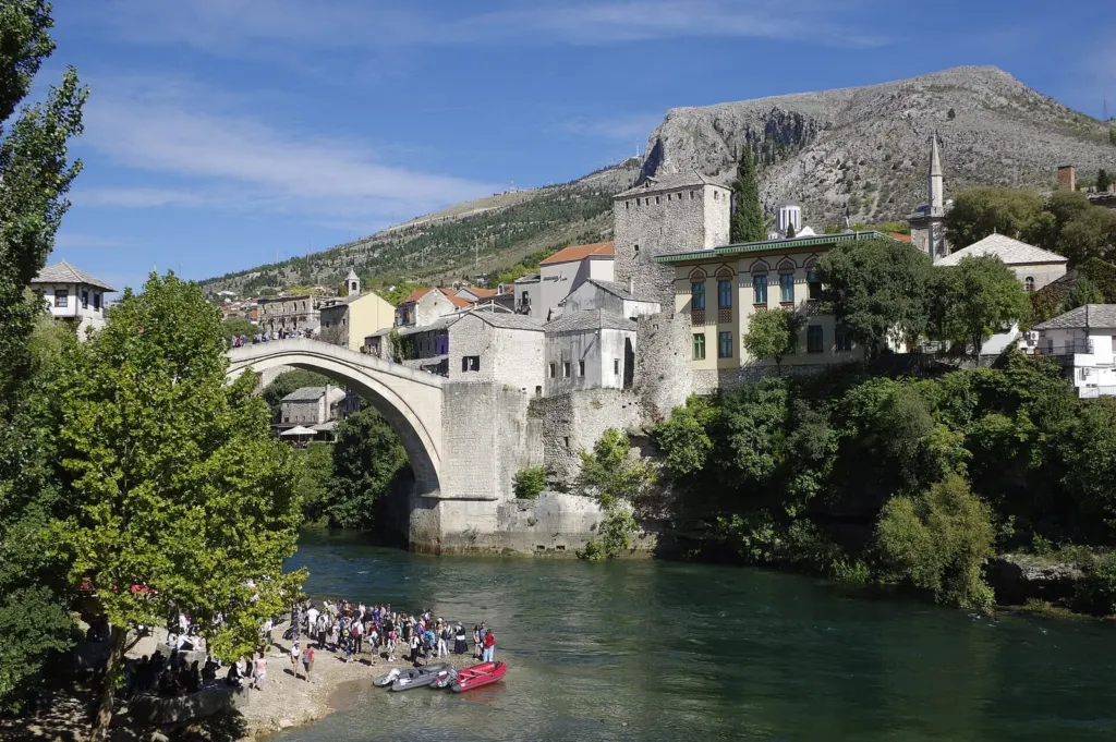 Stari most u Mostaru nad rijekom Neretvom, sa starim gradom i brdom u pozadini