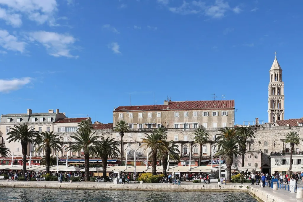 Riva u Splitu s palmama i zvonikom katedrale sv. Duje iznad zidina Dioklecijanove palače