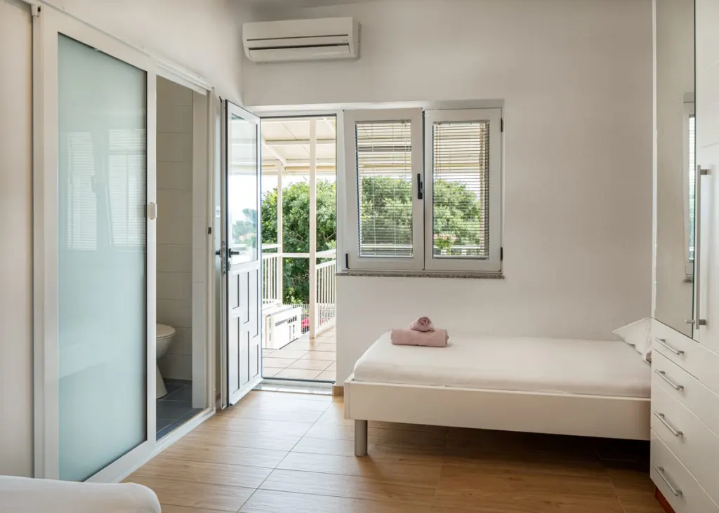 Apartmán 2, pokoj s postelí, dveřmi do koupelny a východem na terasu