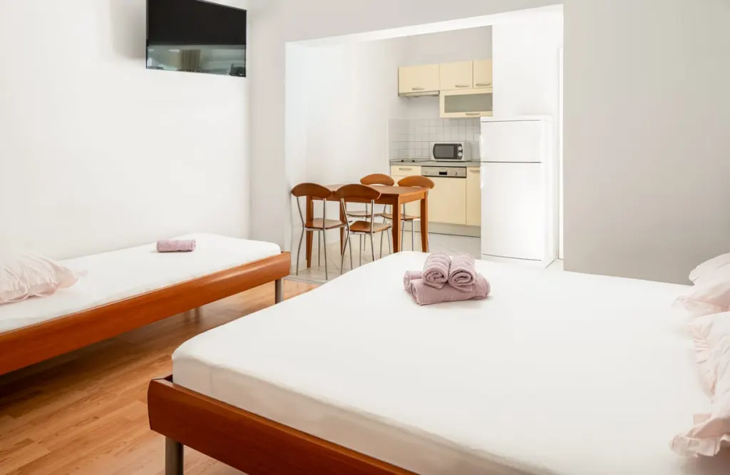 Apartmán 3, pokoj s postelemi, jídelním stolem a kuchyní